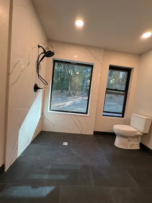 Bathroom project by Barron's Flooring & Home in Pine Grove, CA featuring MSI Calacatta Laza 2cm quartz, Surface Art Absolute 2×2 tile, black, Surface Art Absolute 12×24 tile, black