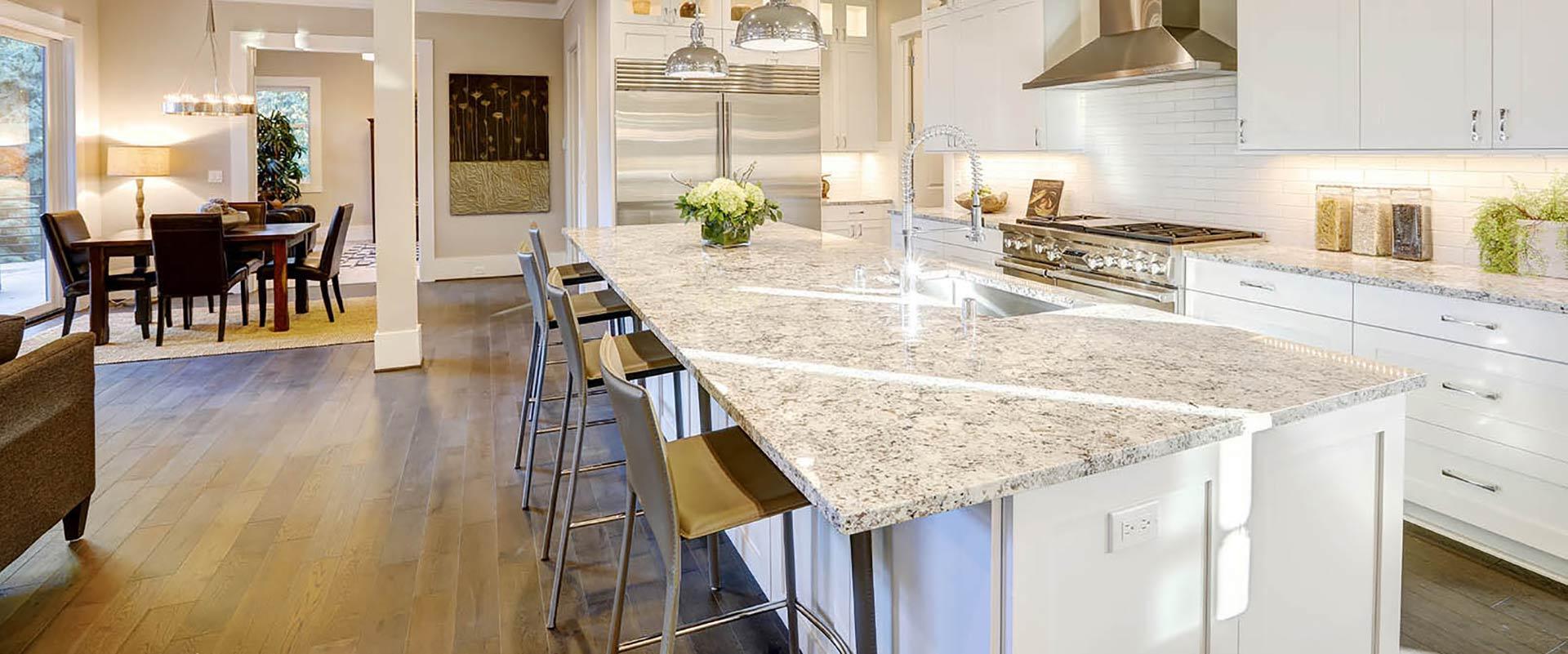 Open kitchen with granite island and dining room beyond, photographed for Barron's
