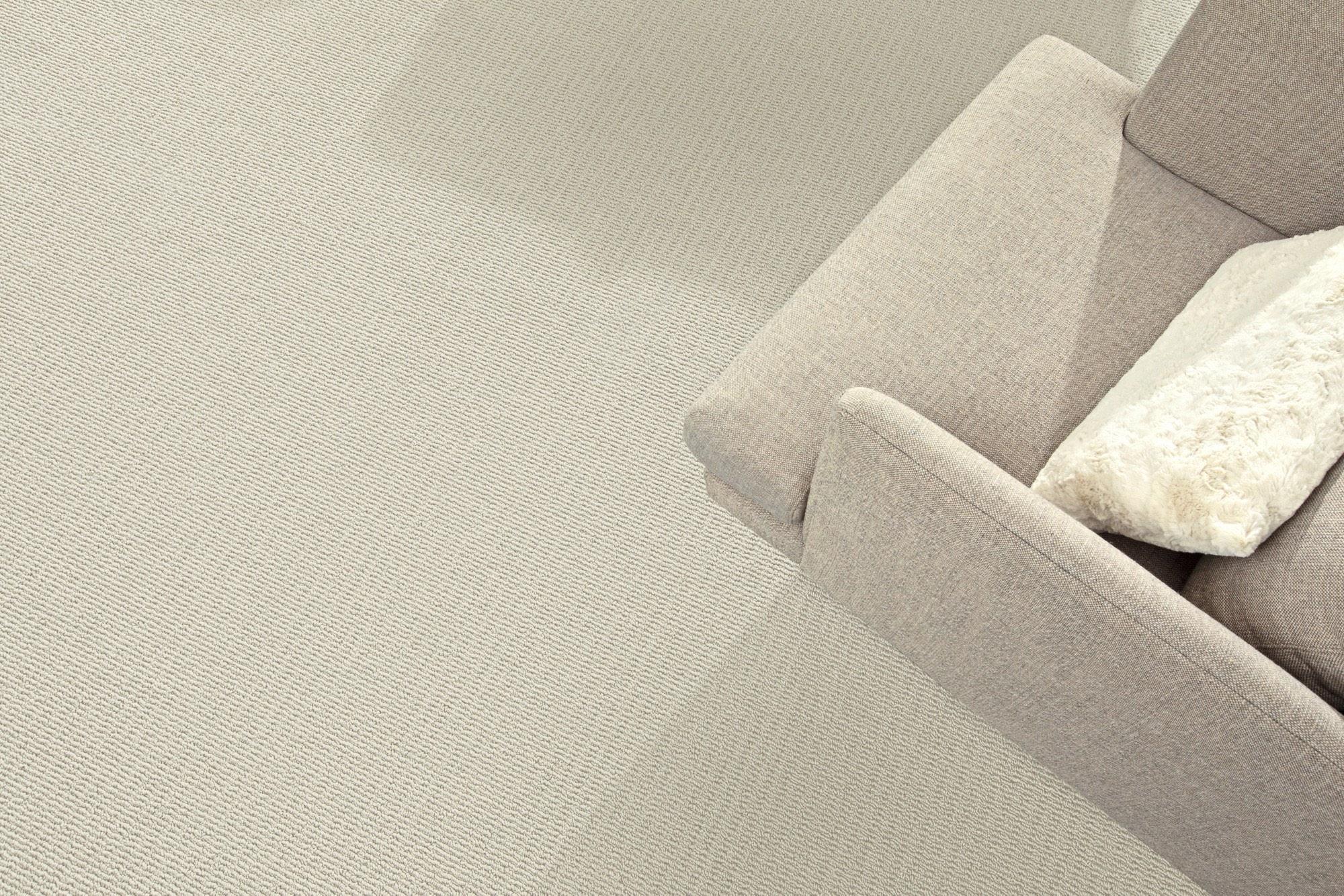 Close-up of Mohawk EverStrand Berber loop carpet next to a sofa