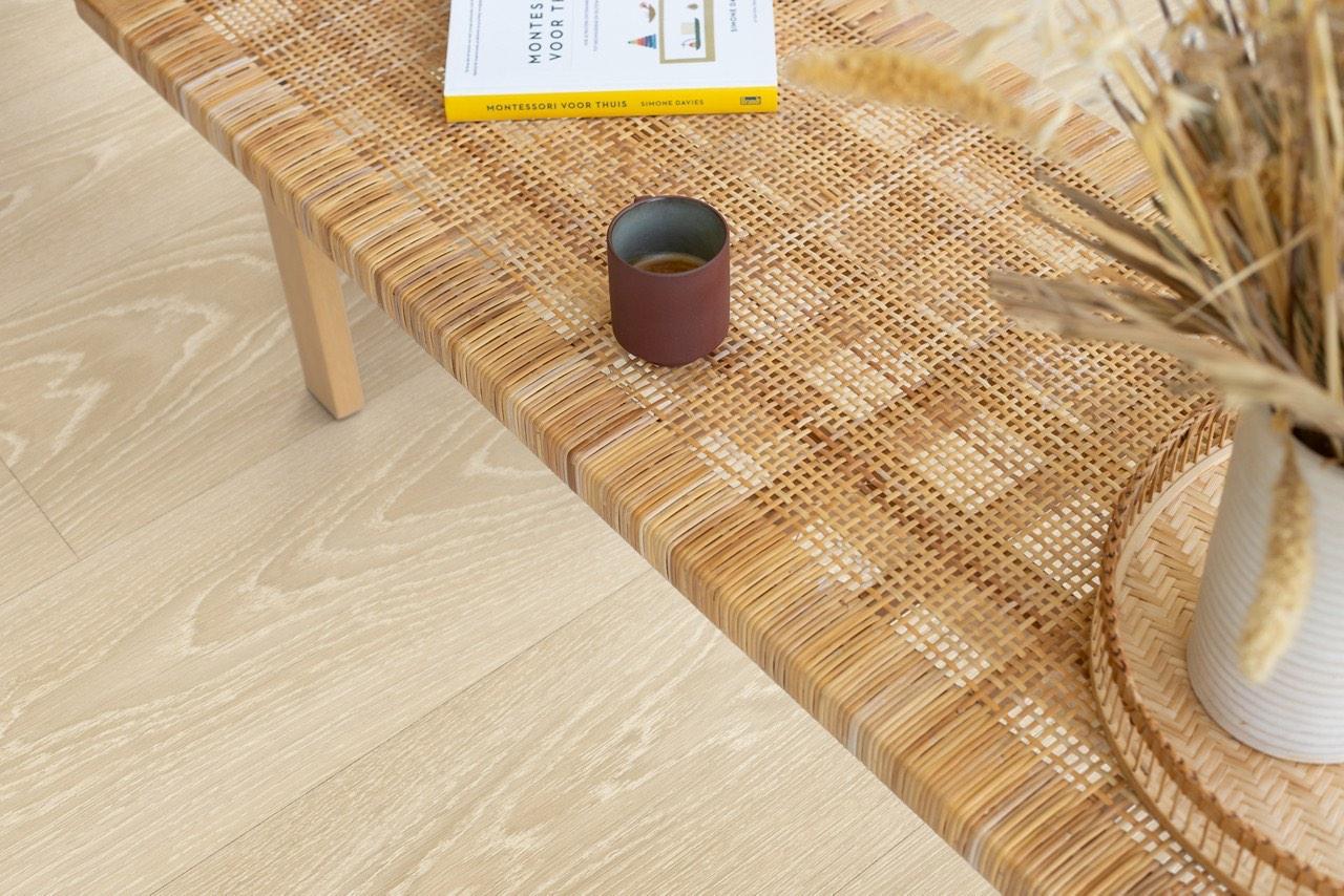 Close-up of Quick-Step Classic wood laminate with a rattan bench corner