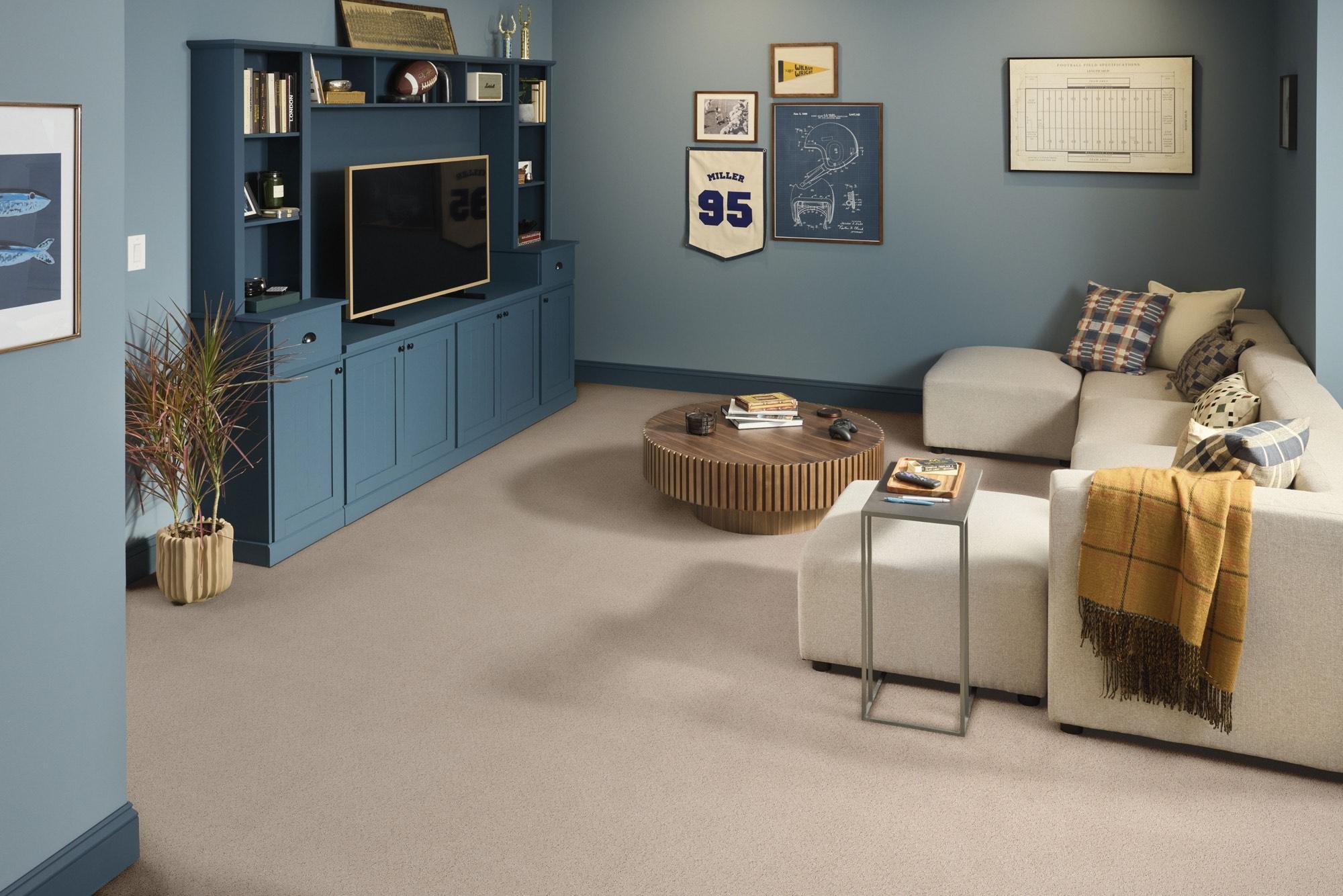 Shaw Floors frieze carpet in a sports-themed family den with sectional sofa