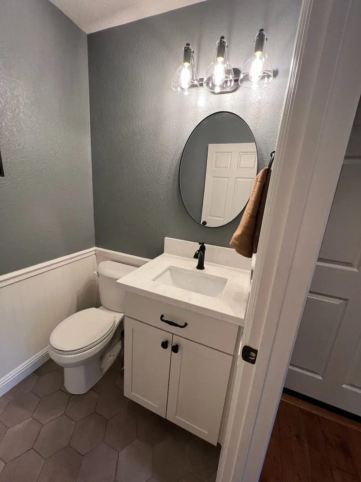 Finished powder room with a floating-look vanity and a round mirror