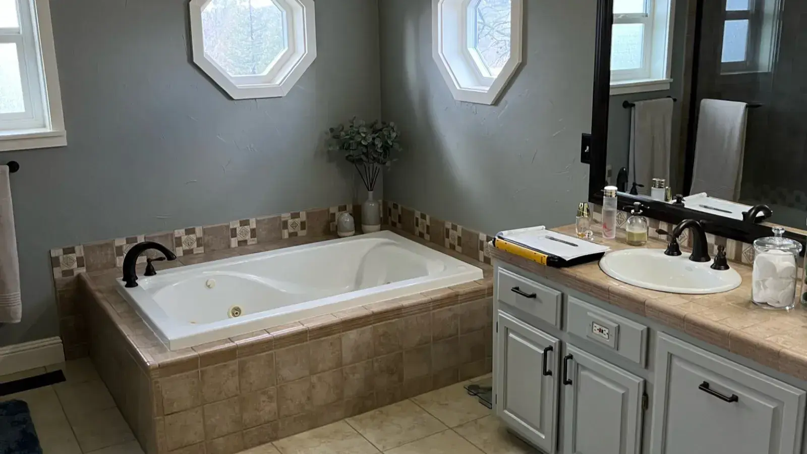 Before: Master bathroom with a dated garden tub and octagonal windows before remodel