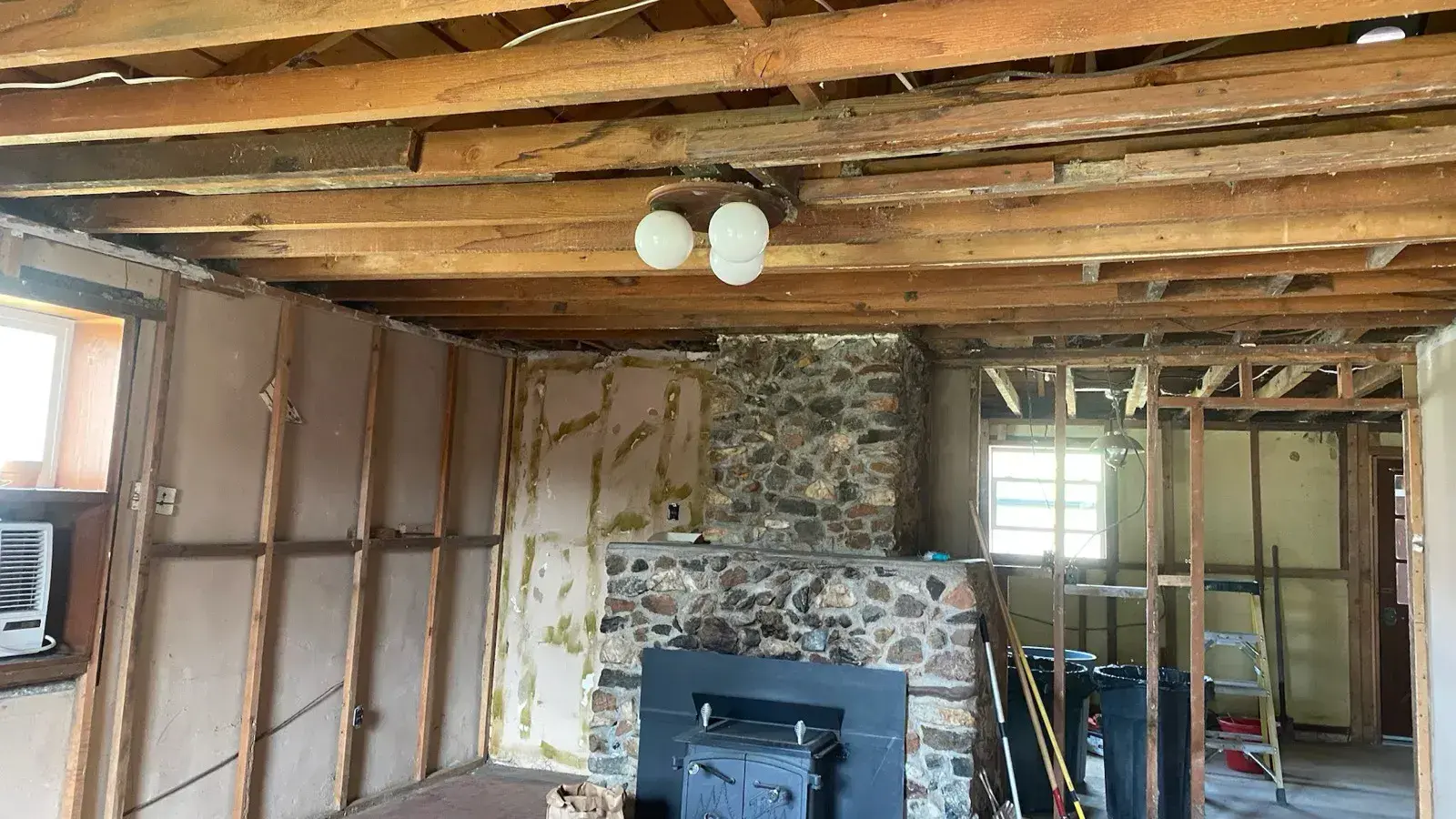 Before: Living room rebuilt with new wood-look floors and a river-rock fireplace
