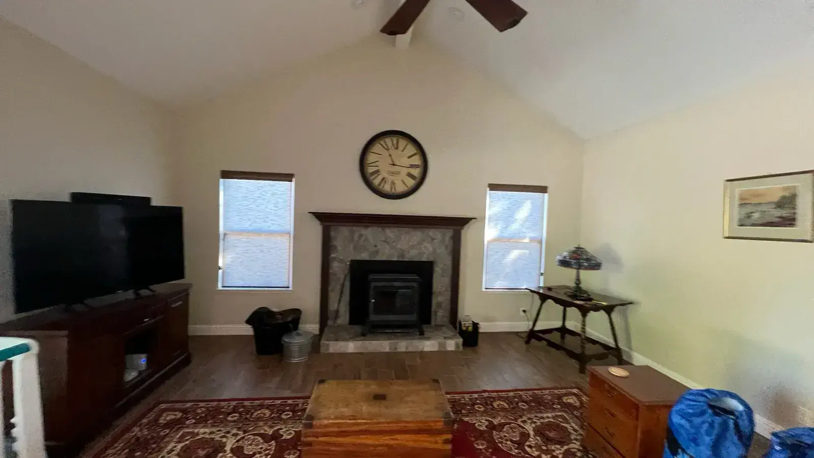 Before: Living room re-floored with wood-look plank and a stacked-stone fireplace
