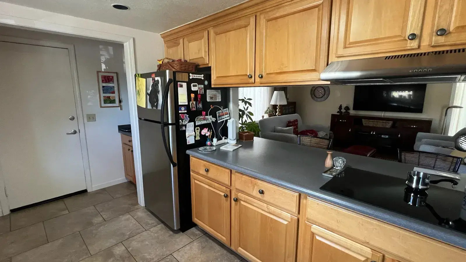 Before: Kitchen with oak cabinets, dark counters, and tile floors before remodel