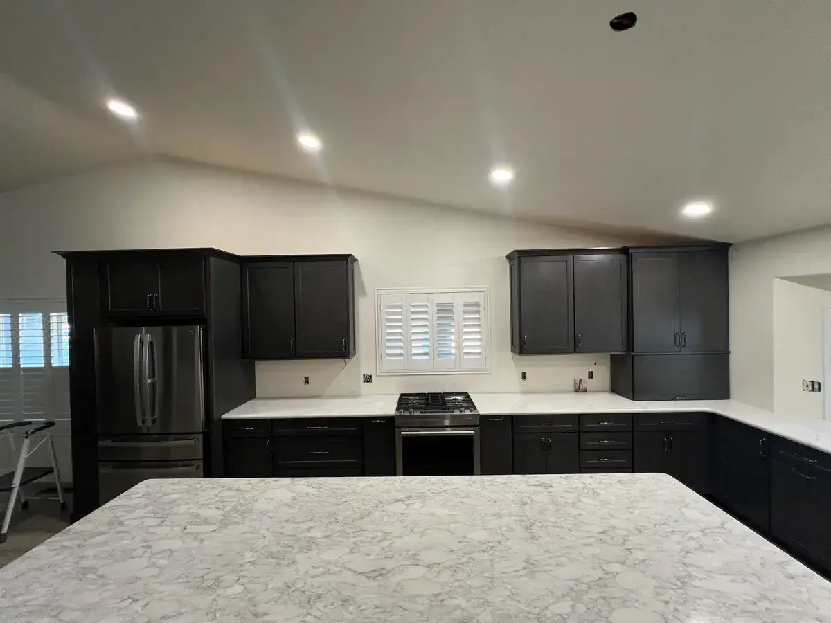 White quartz counters in an open dark-cabinet kitchen
