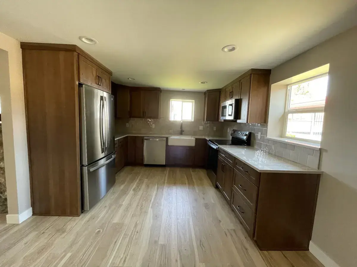 Finished open cherry kitchen with stainless appliances and granite counters